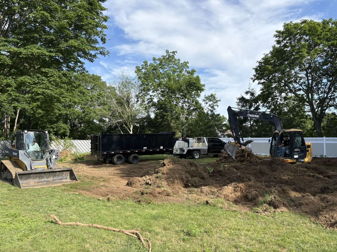 Excavation equipment working on a landscaping project in a residential area.