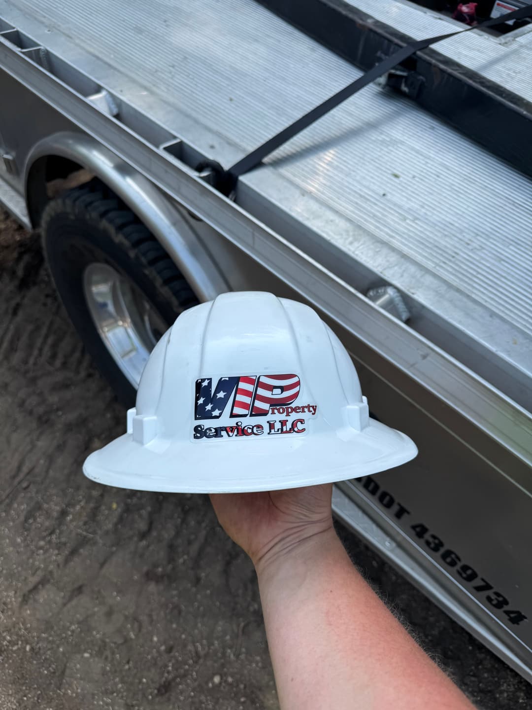 White construction hard hat with American flag logo for VIP Property Service LLC.