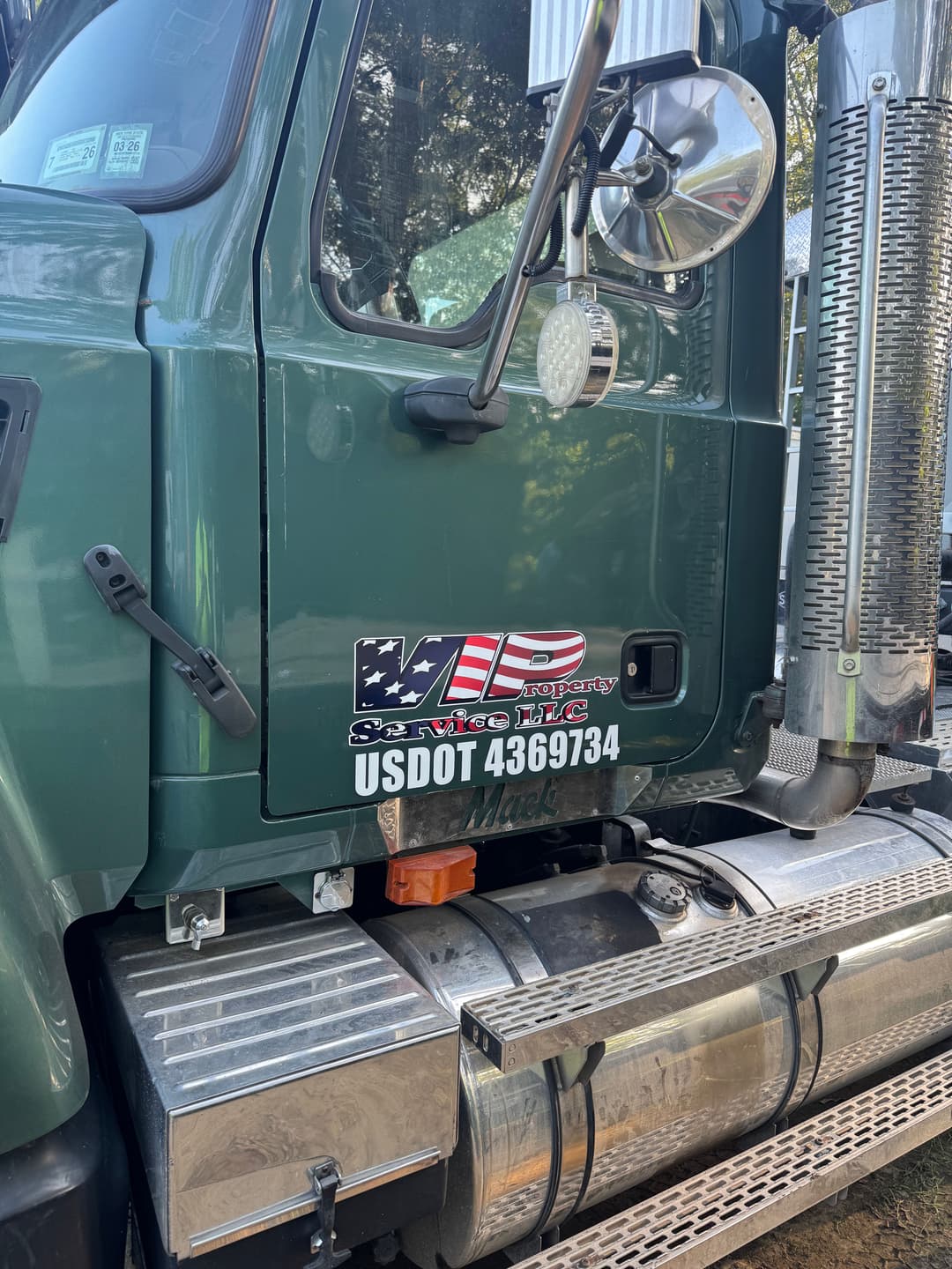Mack truck featuring VIP Services logo and US DOT number 4369734, parked outdoors.