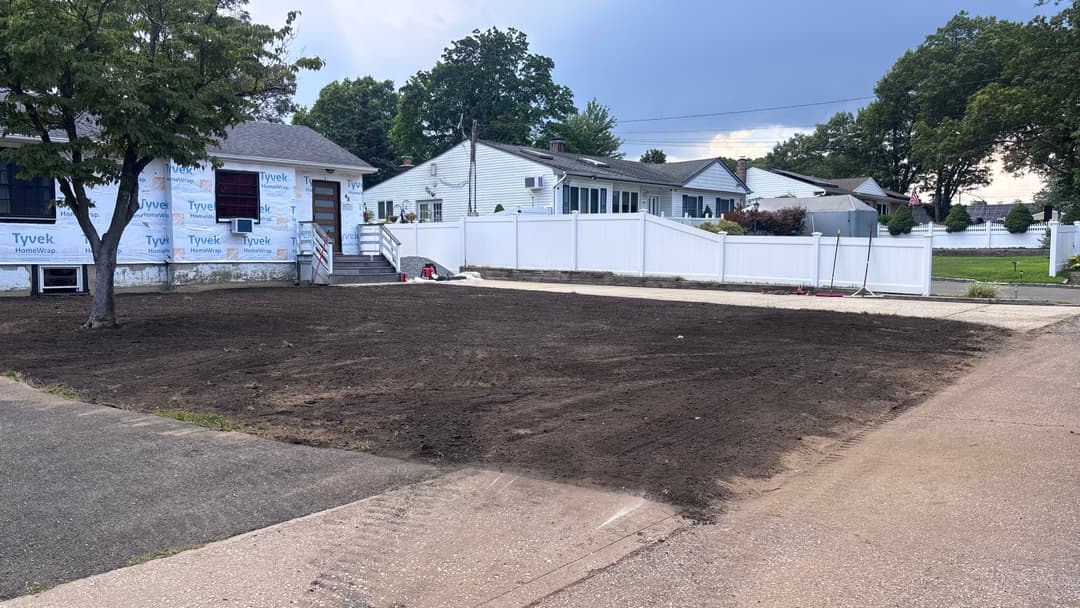 Cleared dirt area in front of home, preparation for landscaping or construction project.
