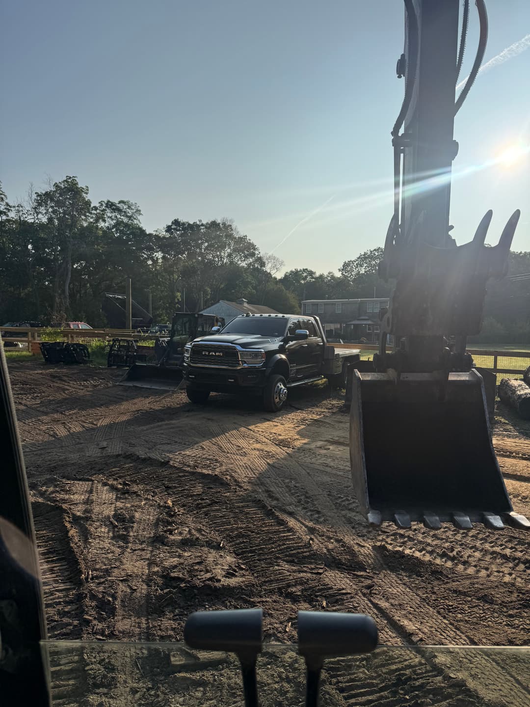 Construction site with heavy machinery and a black RAM truck in the foreground.