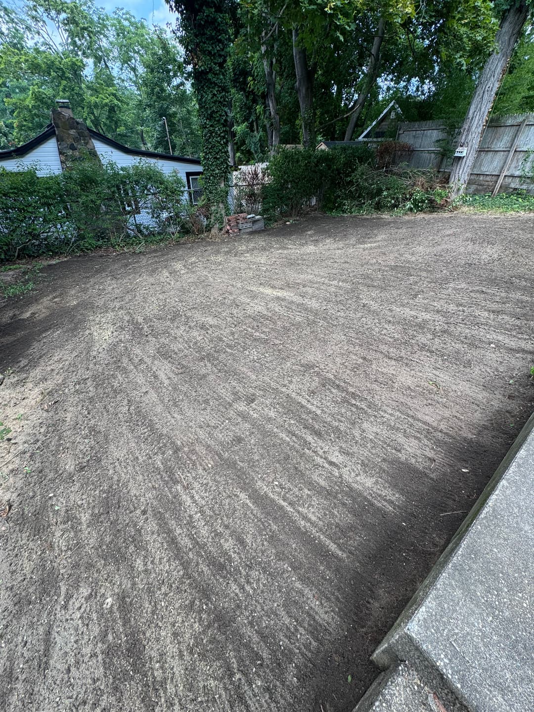 Cleared and leveled backyard soil ready for landscaping or planting.